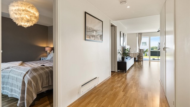 Gangen har downlights i himling og parkett på gulvet.