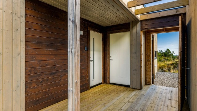 Overbygget inngangsparti med platting mellom hytte og anneks.