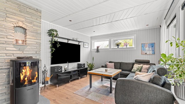Stua har hyggelig sofakrok med fin innsyn til flammene i den stilige peisovnen fra Varde, denne gir lun varme på kalde dager.