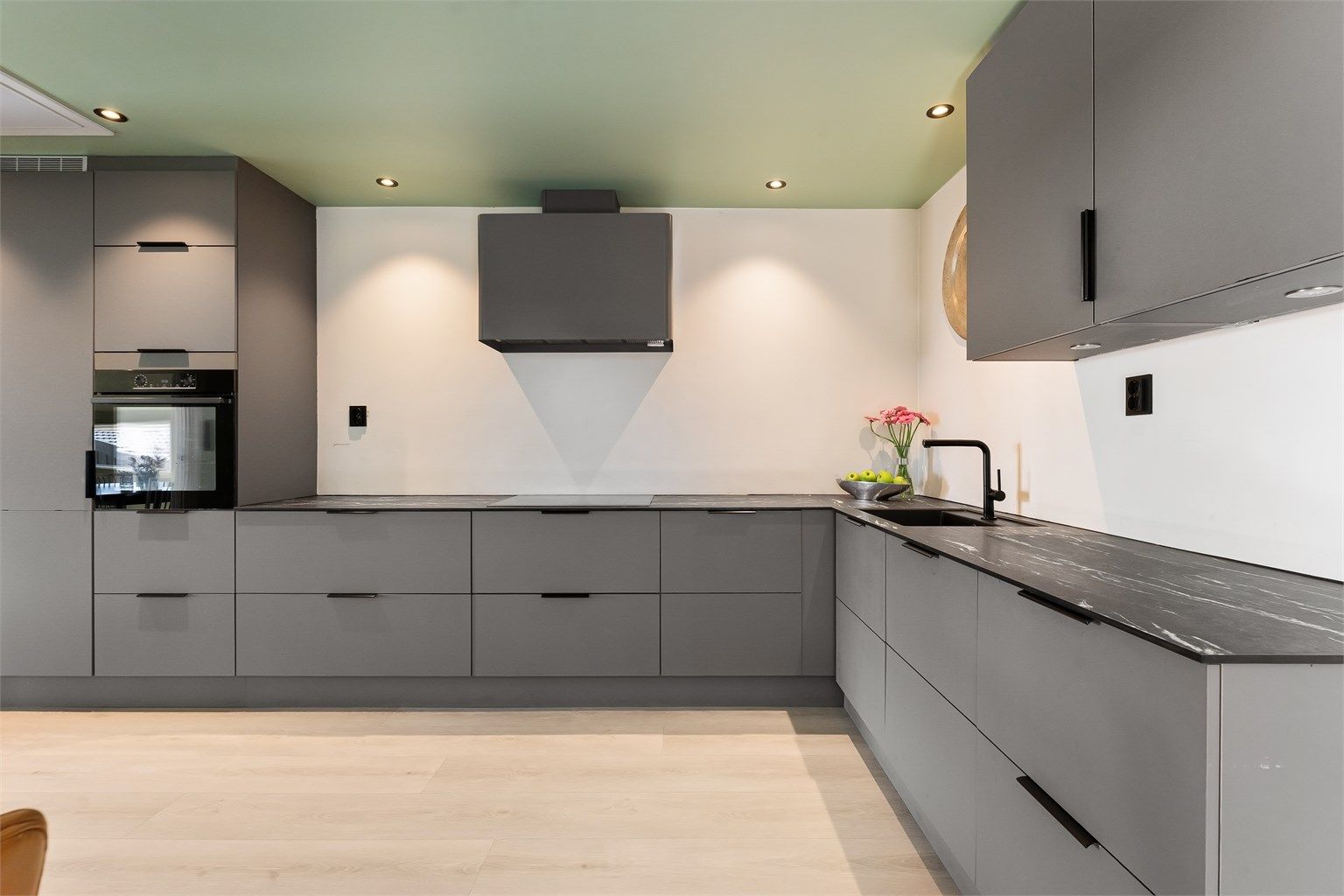 Innredningen er utstyrt med integrerte hvitevarer, inkludert komfyrer i høyskap og nedfelt induksjonstopp med komfyrvakt.