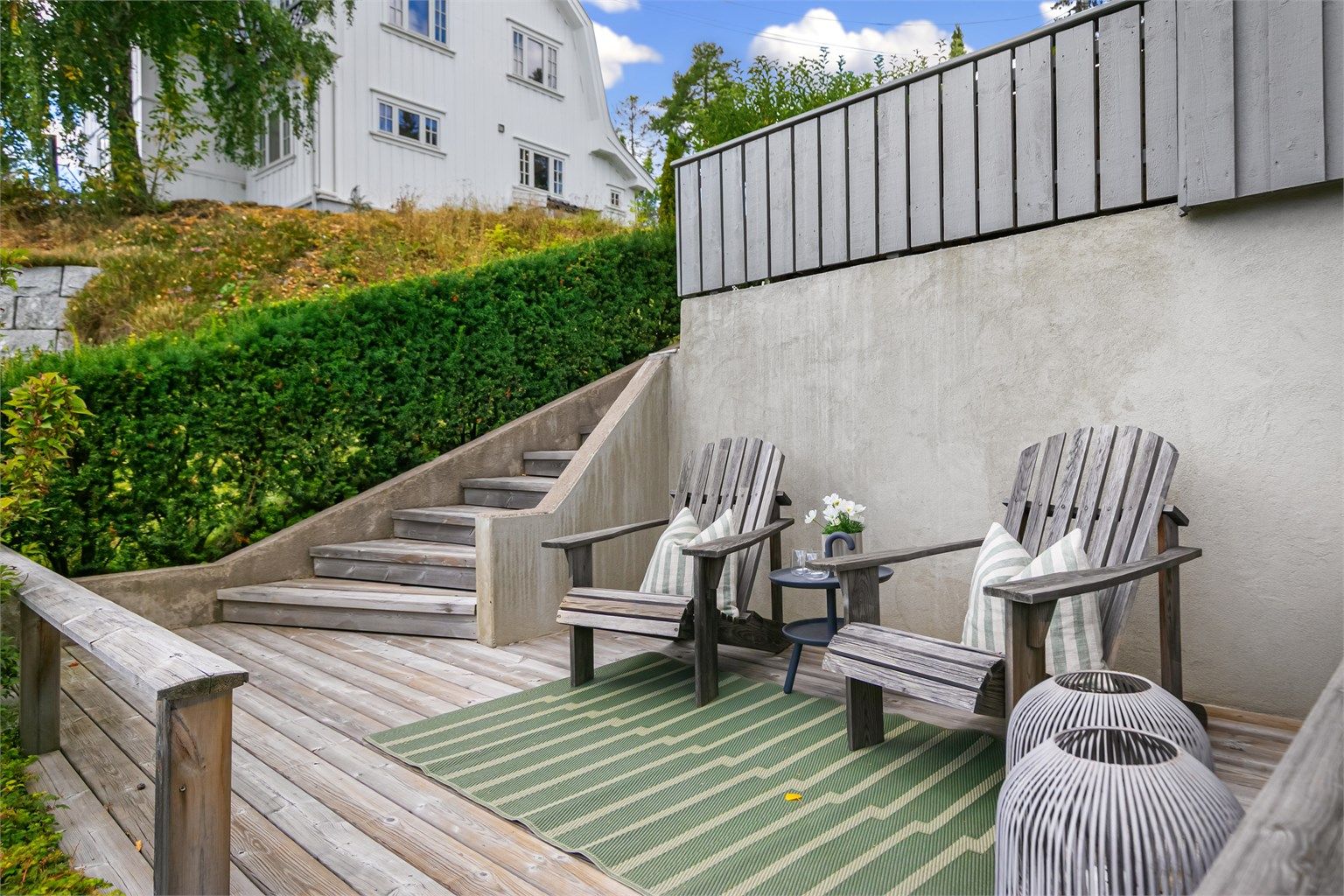 Terrasse 2 i trekonstruksjon med trappeforbindelse ned til hagen.