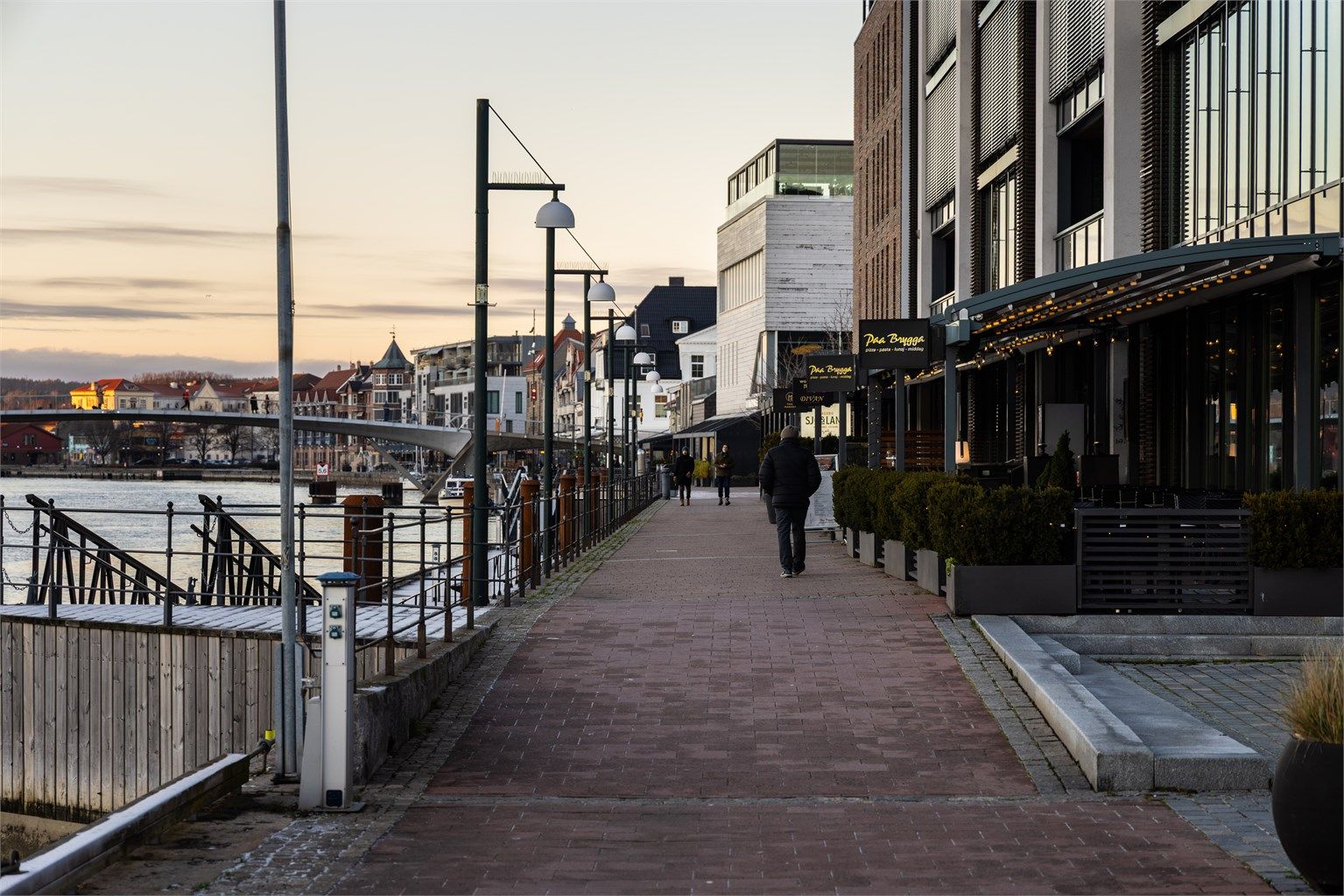 Via Bryggepassasjen går du rett ut på promenaden hvor det er yrende liv sommerstid. Leiligheten ligger på motsatt side.