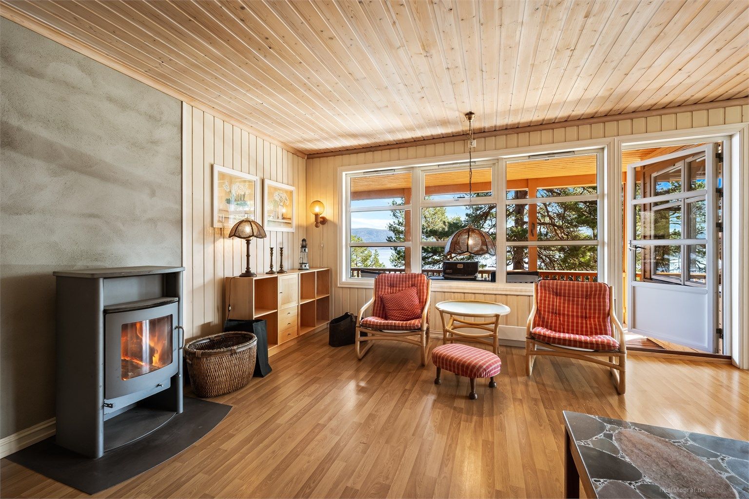 Stuen har en peisovn fra 2002 som gir ekstra varme og hygge. Herfra er det direkte utgang til den overbygde terrassen.