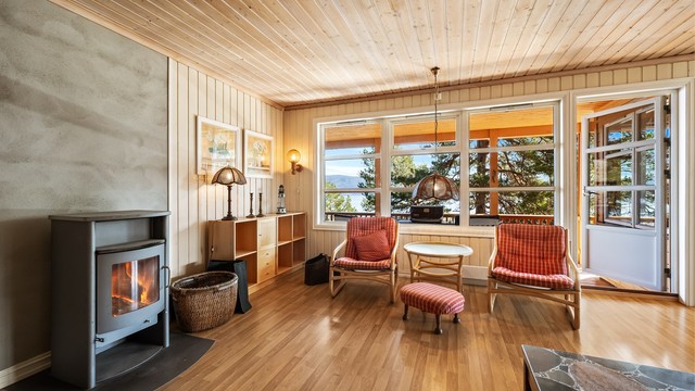 Stuen har en peisovn fra 2002 som gir ekstra varme og hygge. Herfra er det direkte utgang til den overbygde terrassen.