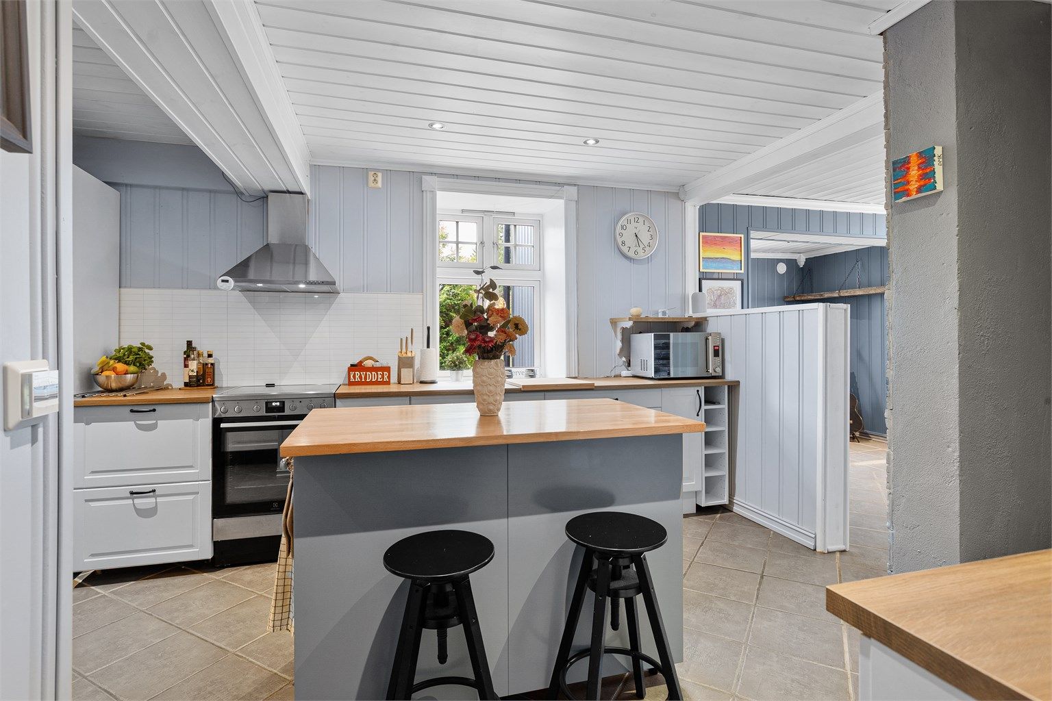 Innredet med komfyr, oppvaskmaskin og kjøl/frys, ventilator på vegg over komfyr