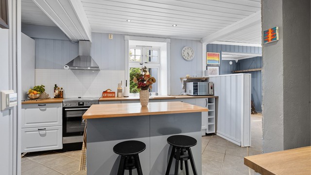 Innredet med komfyr, oppvaskmaskin og kjøl/frys, ventilator på vegg over komfyr