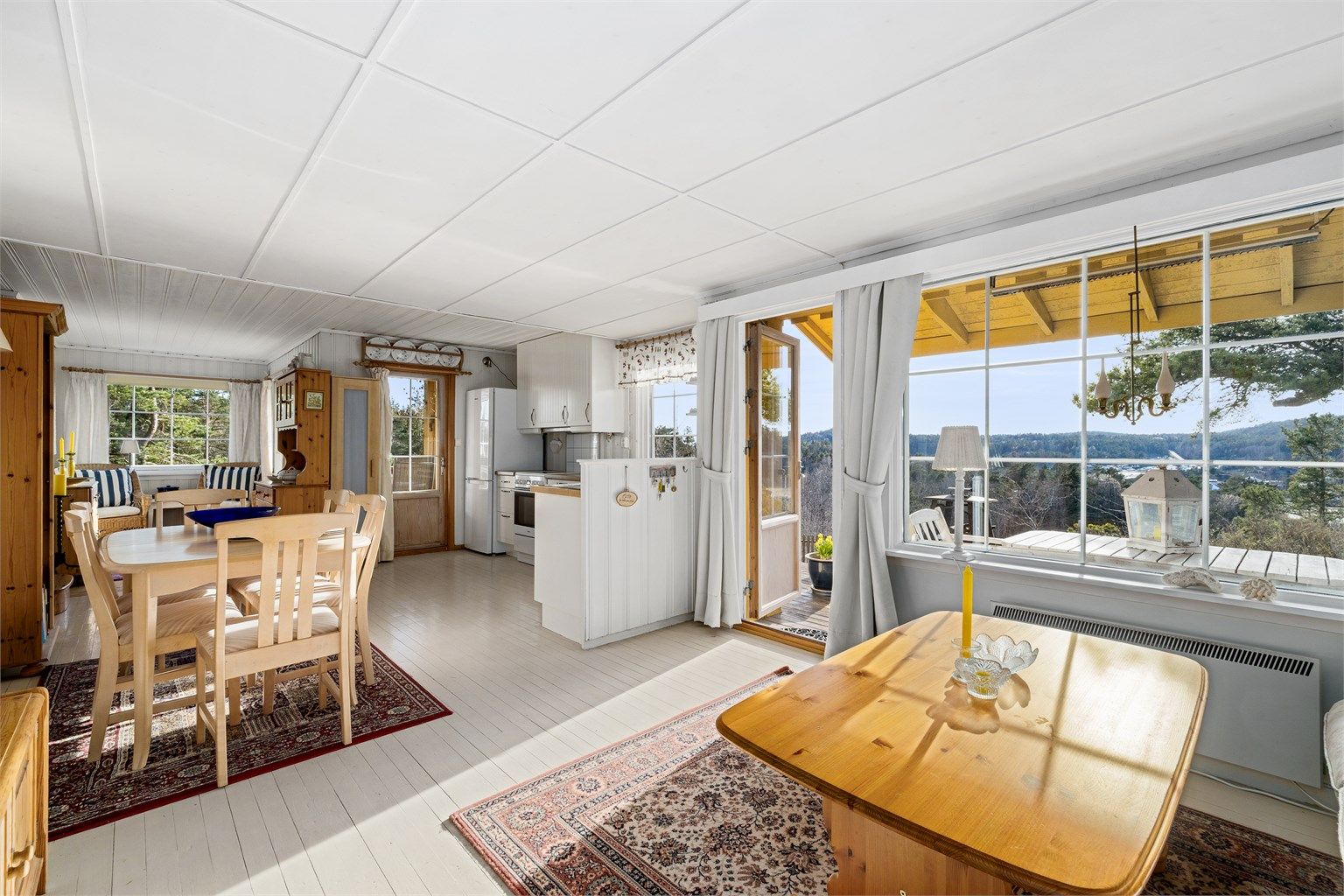 ET VIRKELIG ALLROM: Et stort oppholdsrom med kjøkken, stue, sofakrok og peis.