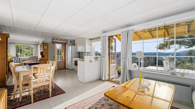 ET VIRKELIG ALLROM: Et stort oppholdsrom med kjøkken, stue, sofakrok og peis.