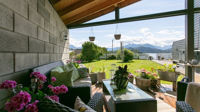 Den overbygde terrassen har plass til sofagruppe og utsyn mot hagen.