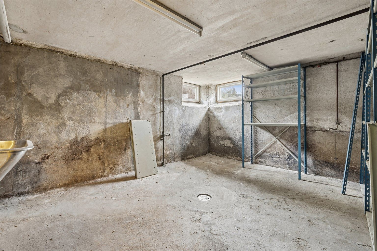 Uinnredet kjellerrom med støpt gulv.