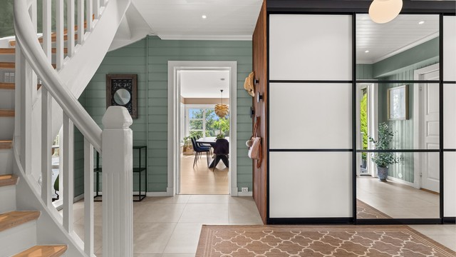 Romslig og innbydende entré med 60x60 fliser på gulv med gulvvarme, og stor skyvedørsgarderobe. Takhøyde på ca. 2,56 meter bidrar til en luftig og åpen romfølelse.