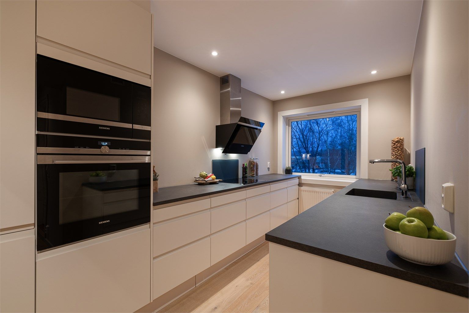 Kjøkken med moderne uttrykk og løsning uten overskap som gir et luftig og ryddig preg