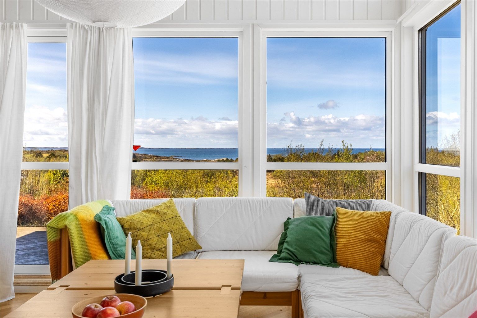 Lys og luftig stue med store vindusflater som slipper naturen inn – nyt en fantastisk, uhindret utsikt mot hav og horisont rett fra sofaen.