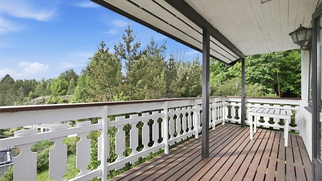 Overbygget veranda med tregulv og utgang fra et av soverommene.