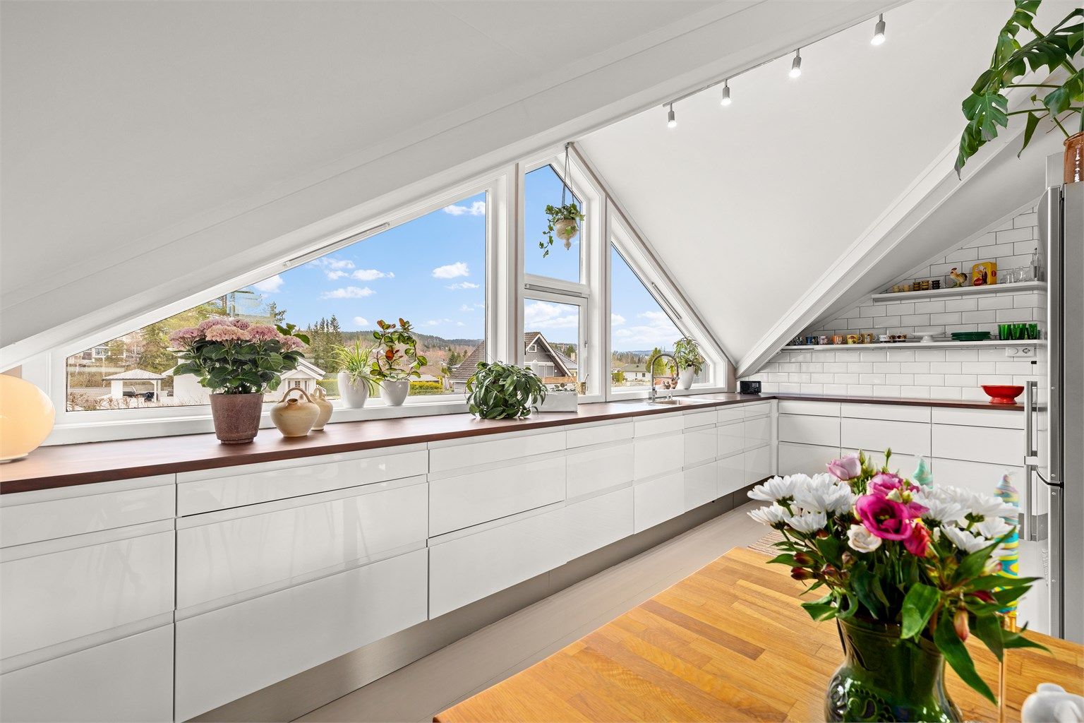 Benkeplatene i heltre ble pusset ned og overflatebehandlet i 2025, og gir en varm kontrast til de hvite frontene.