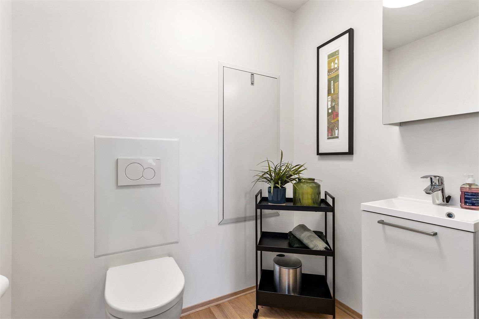 Separat toalettrom med vegghengt toalett, servant og vannbåren gulvvarme.