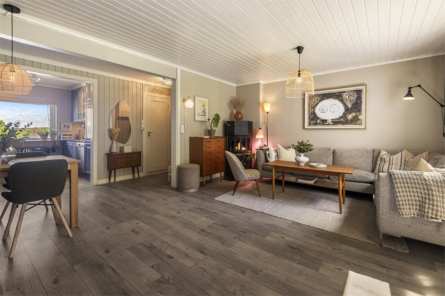 En åpen og sosial sone med plass til både sofagruppe og spisebord.