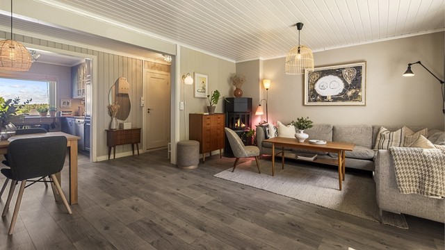 En åpen og sosial sone med plass til både sofagruppe og spisebord.