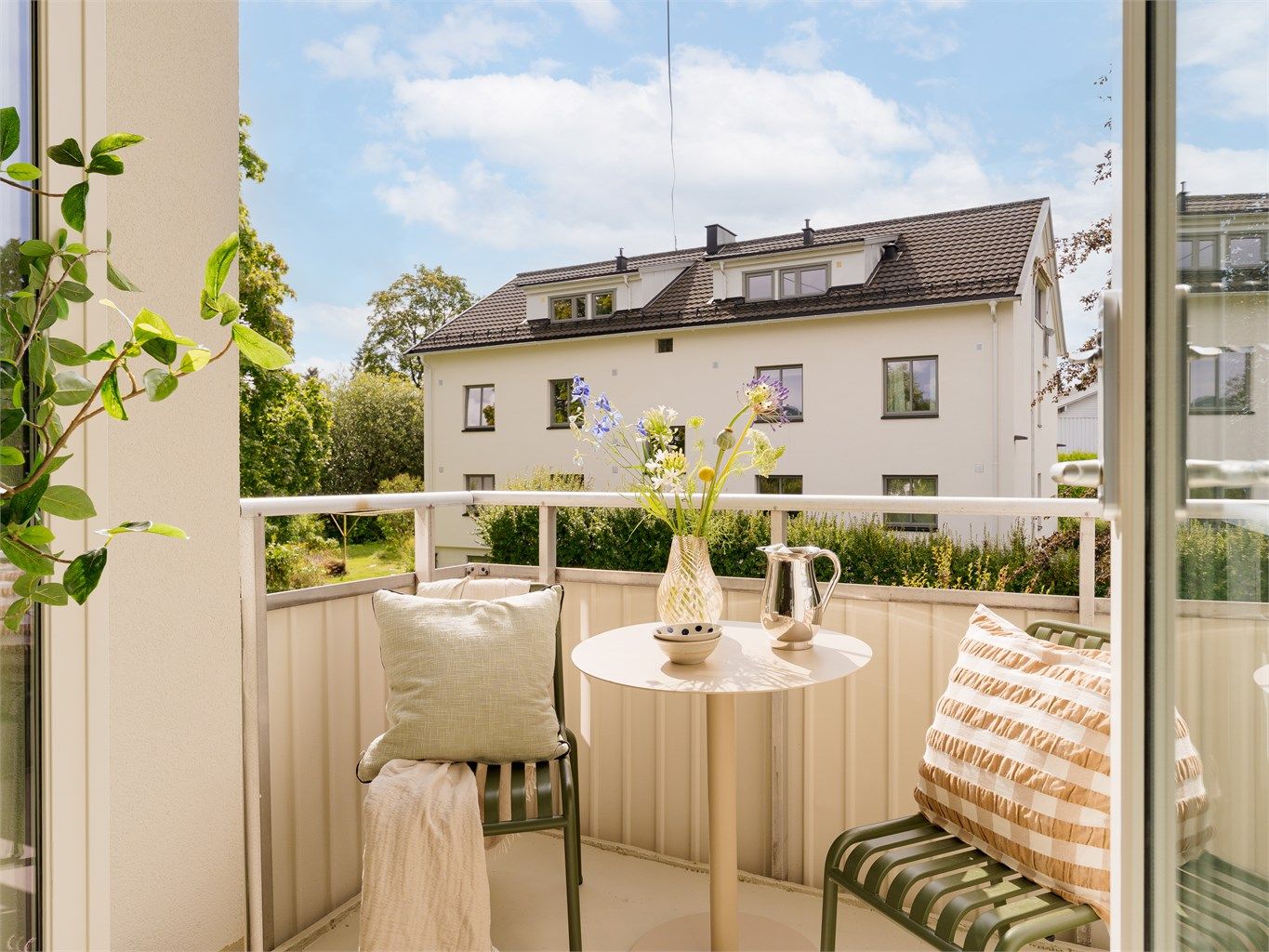 Balkongen vender ut mot sameiets rolige og grønne fellesarealer.