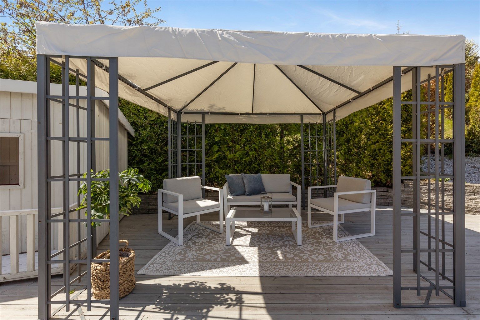 Sofagruppen under pergola med teltduk forlenger utetiden, her kan du sitte også om det er litt dårlig vær.