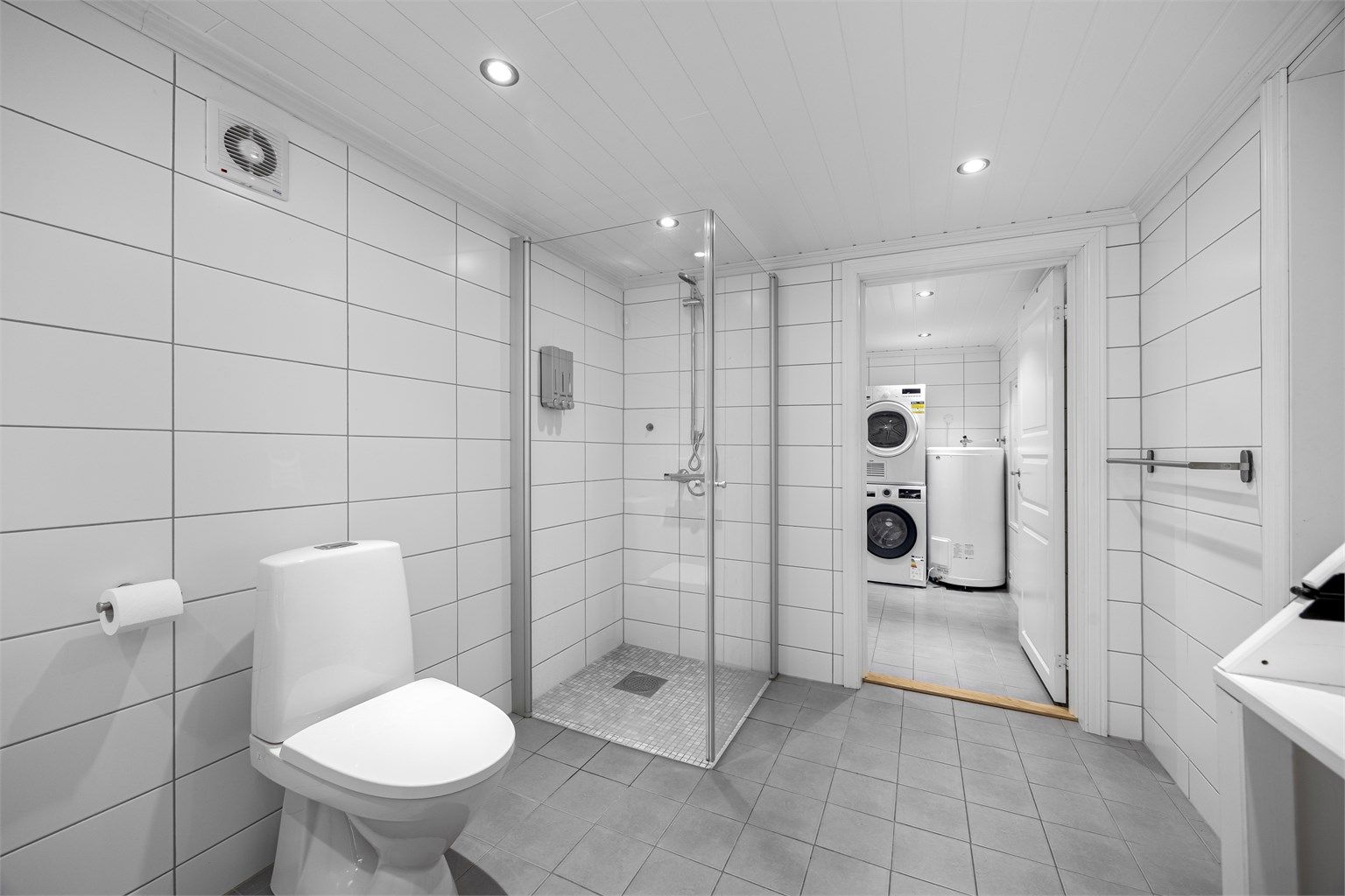 I tillegg til badekar har badet et separat dusjhjørne med glassvegger. Det er mekanisk avtrekk.
