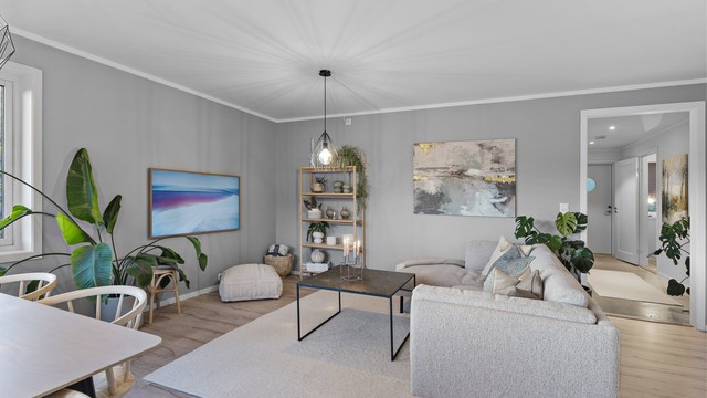 Oppholdsrommet er innredet med en-stavs laminat på gulv og malte veggflater.