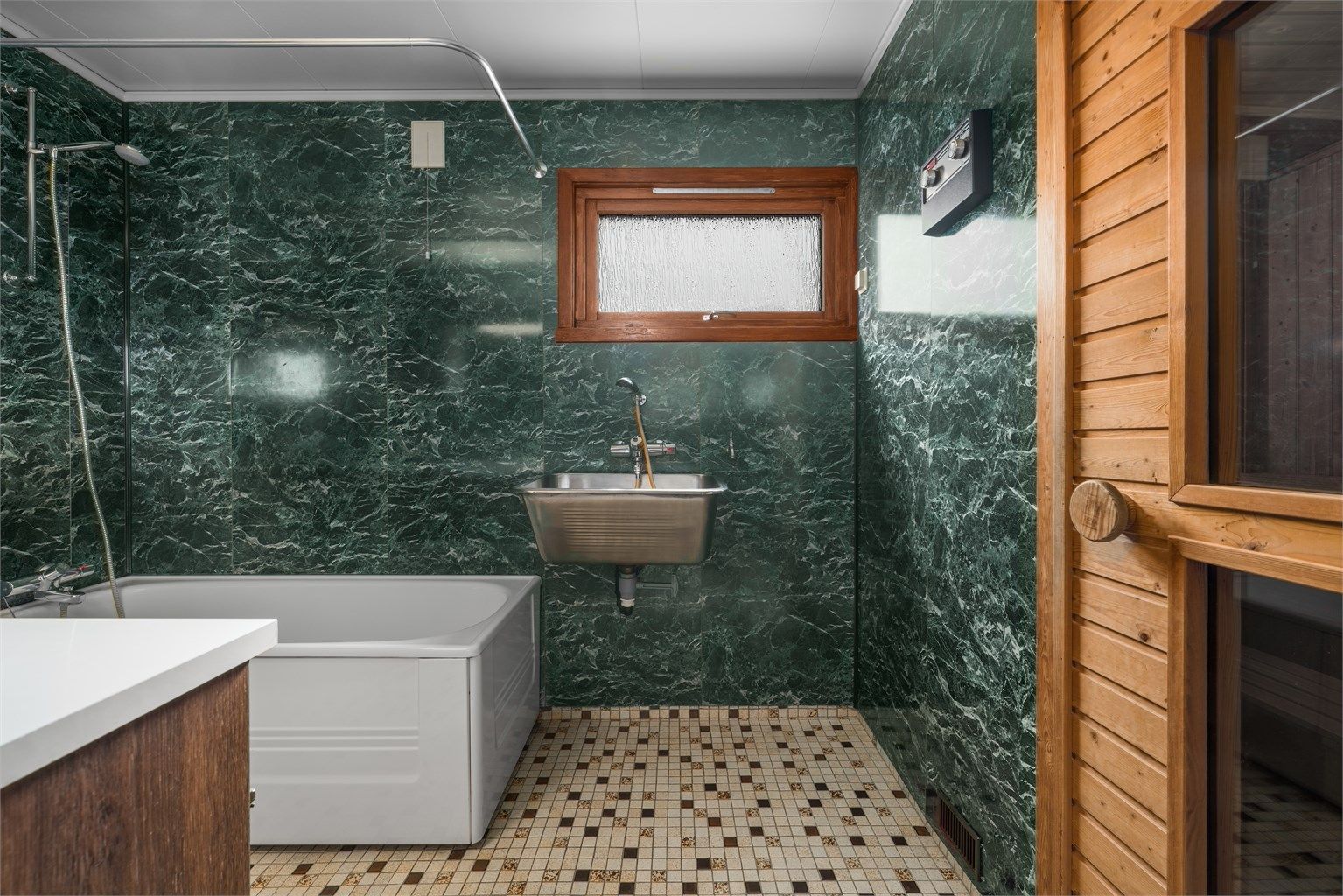 Badet i første etasje har gulvvarme, våtromsplater på veggene, badekar og en praktisk utslagsvask i stål.