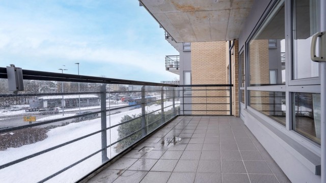 Terrasse mot syd med rekkverk av glass og stål. Her er det også utvendig stikkontakt