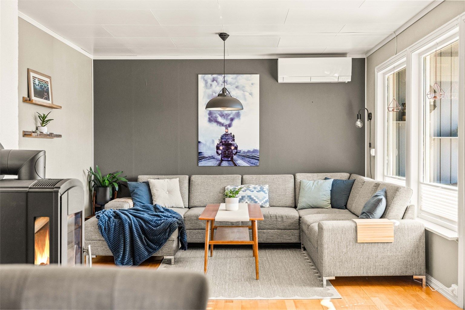 Lys og hyggelig stue med god plass til sofagruppe, peisovn og varmepumpe fra 2019. Foto: Anders Botnmark. 