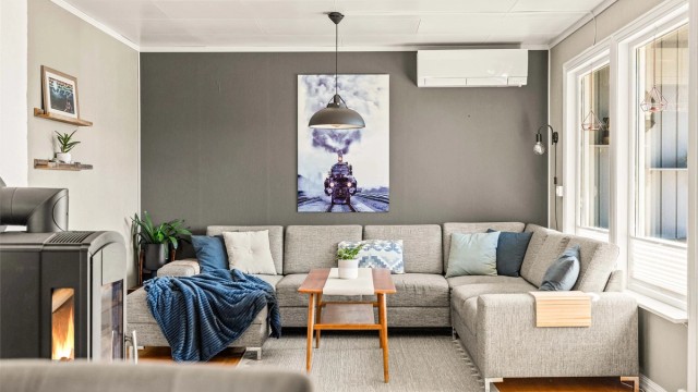 Lys og hyggelig stue med god plass til sofagruppe, peisovn og varmepumpe fra 2019. Foto: Anders Botnmark.