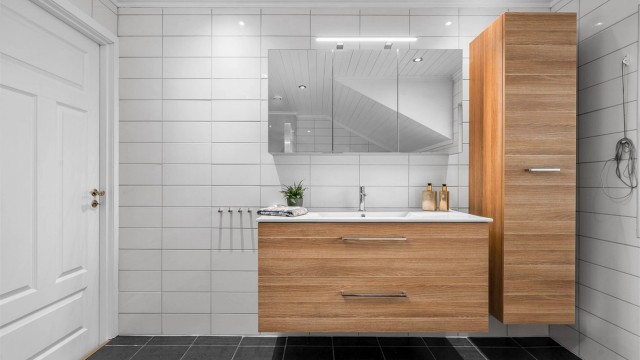 Baderomsinnredning fra Dansani med servant og speilskap, samt et praktisk høyskap for ekstra oppbevaring.