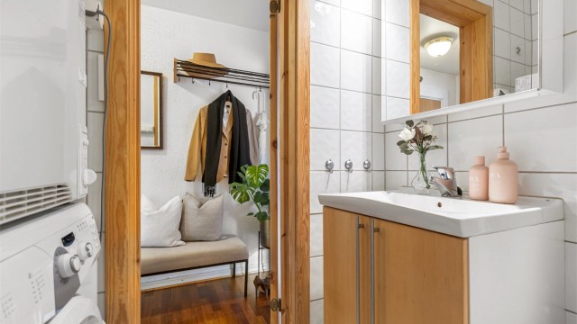 Badet er utstyrt med dusjhjørne med glassvegger, servantskap og toalett.