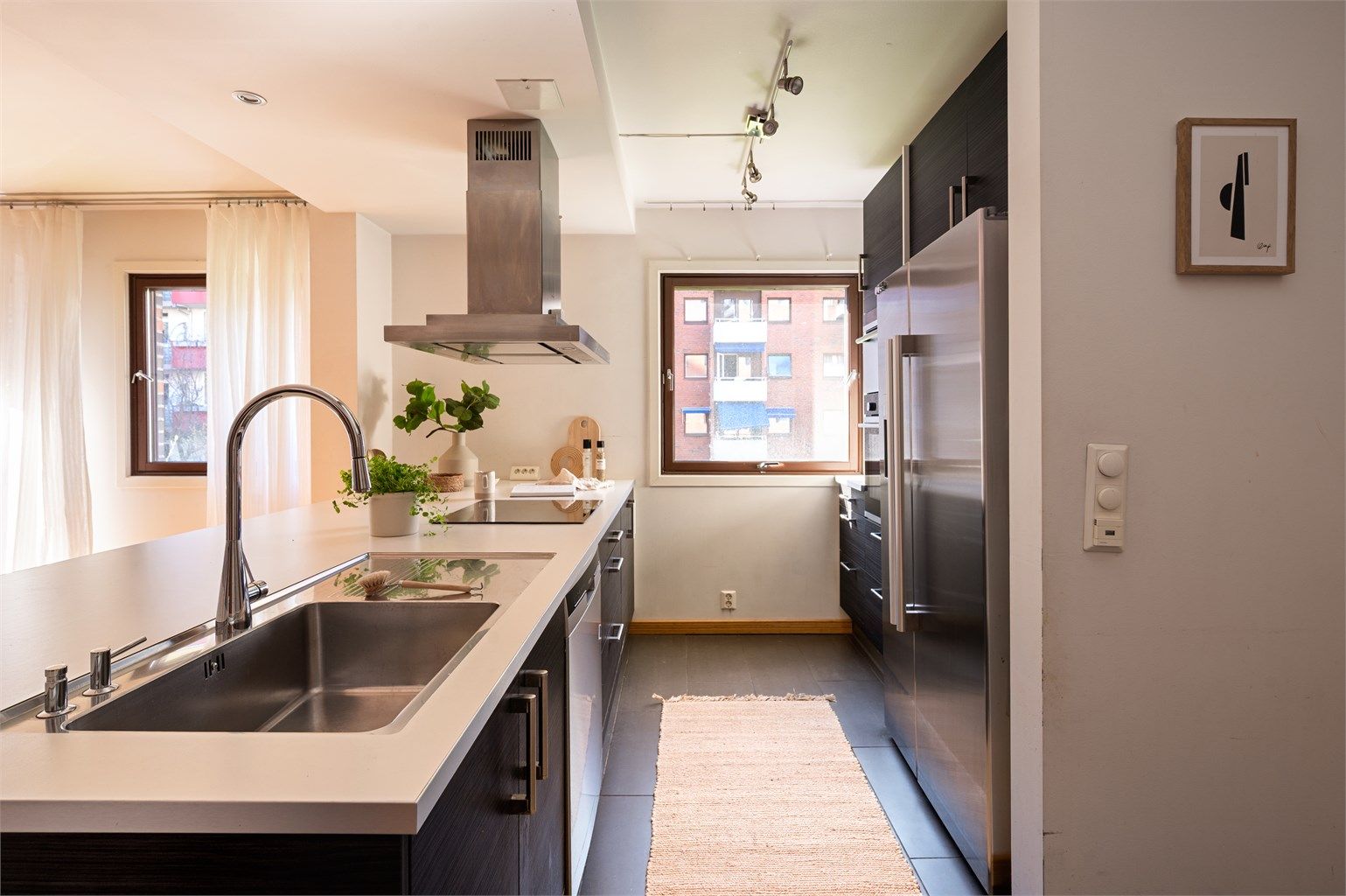 Kjøkkenøyen gir godt med benkeplass og har integrert kjøkkenvask med armatur, platetopp og oppvaskmaskin. I tillegg er det integrert stekeovn, mikrobølgeovn og frittstående kjøleskap.