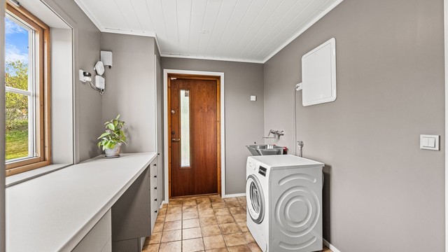 Vaskerom med separat inngang, god benkeplass og opplegg for vaskemaskin.