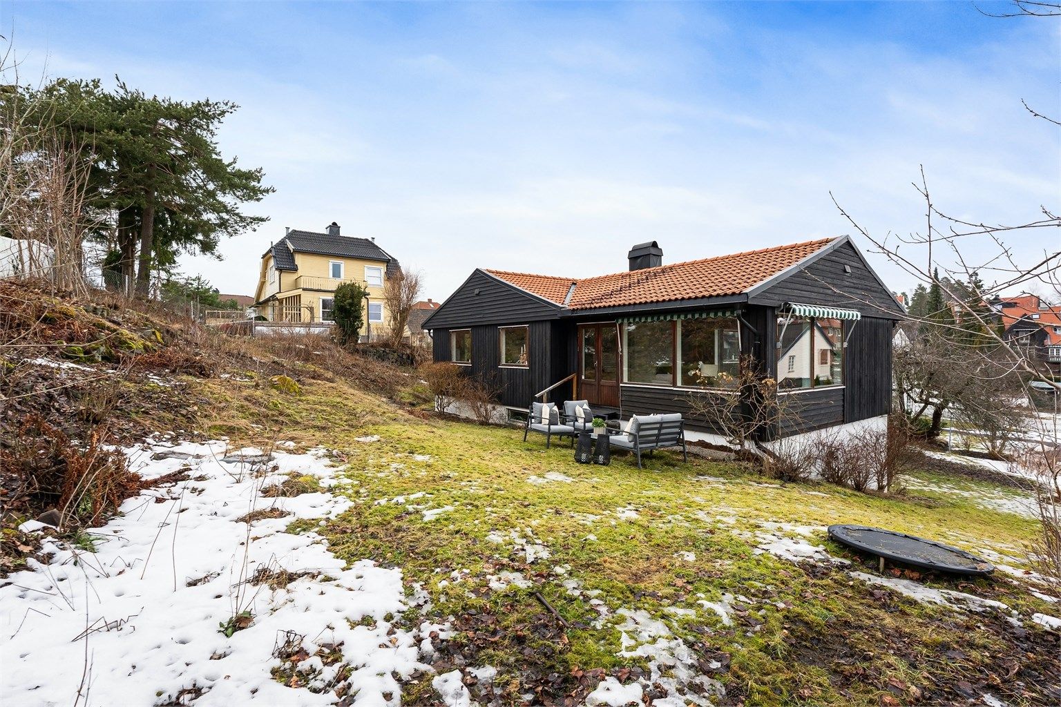 Den svakt skrånende tomten er opparbeidet med plen og gir gode solforhold.