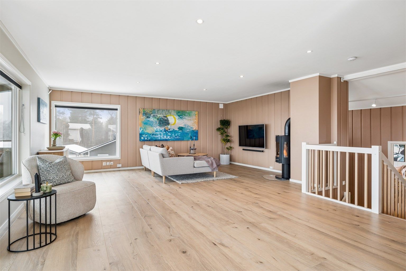 Stuen har en koselig peisovn som bidrar godt til både oppvarming og atmosfæren i rommet.