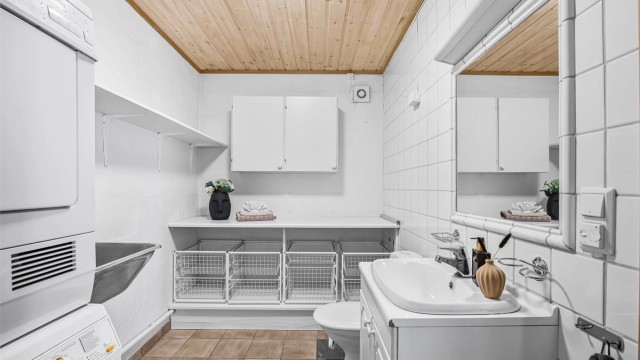 Romslig vaskerom med god arbeidsbenk, toalett og vask. Opplegg for tørk-og vaskemaskin.
