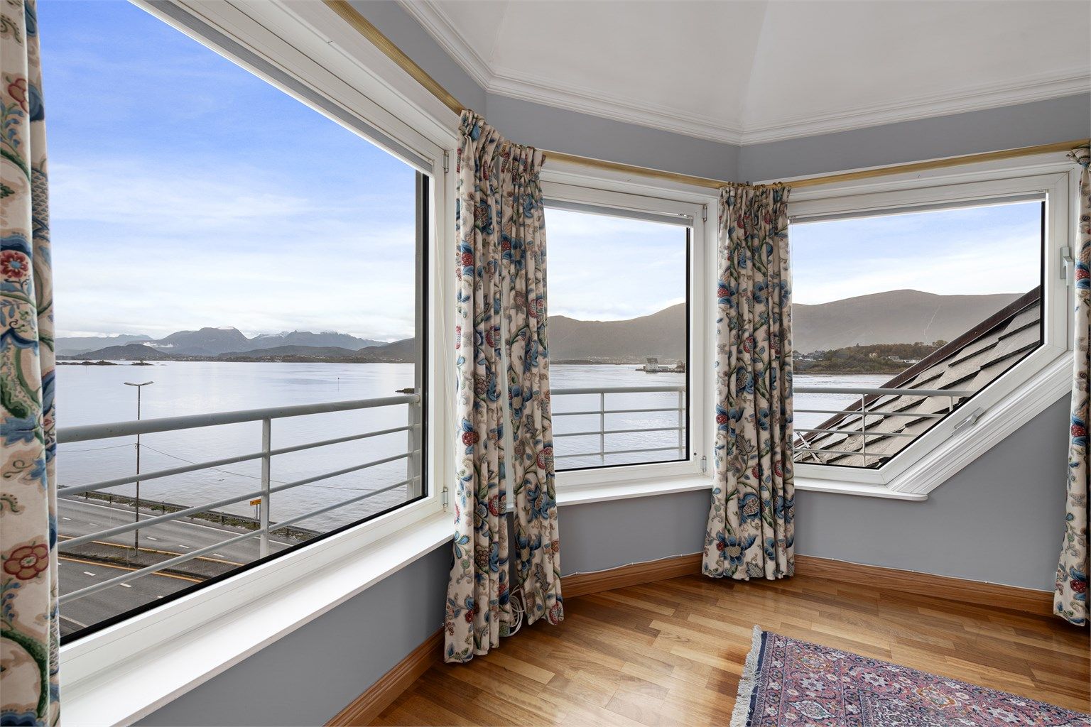 Store vindusflater gir et vidstrakt utsyn over fjorden og landskapet omkring.