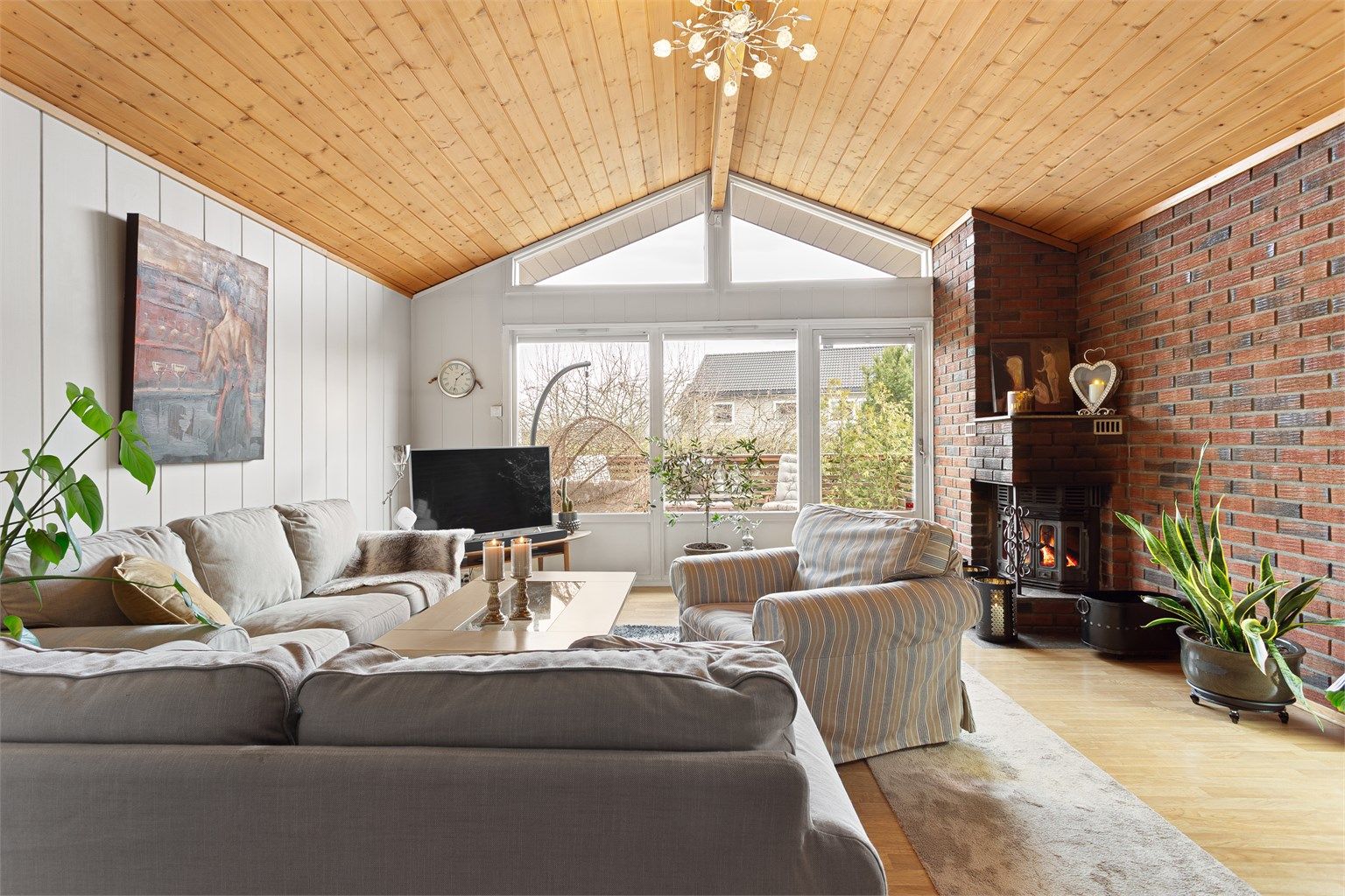 En murt peis med innsats skaper en lun og hyggelig stemning i stuen. Teglsteinsveggen gir rommet karakter.
Foto: Ole Thorgeir Solheim Thoresen