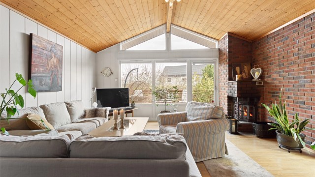 En murt peis med innsats skaper en lun og hyggelig stemning i stuen. Teglsteinsveggen gir rommet karakter.
Foto: Ole Thorgeir Solheim Thoresen