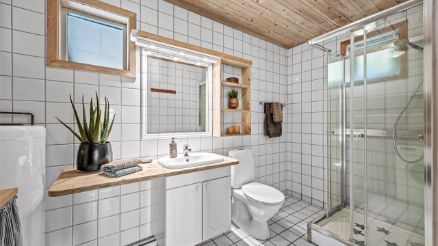 Hovedbad i 1 etg.: Romslig og godt utnyttet bad med varmtvannsbereder, servantskap og dusjkabinett.