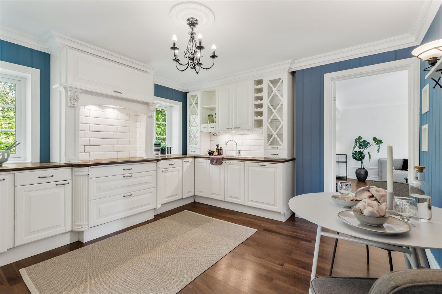 Lyst og romslig kjøkken med plass til mindre spisebord med stoler.