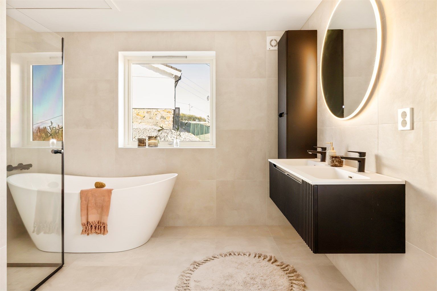 Dette badet sikrer deg en god start på dagen. Her har du rikelig med oppbevaringsplass i møbler som gir et rent uttrykk. God speilbelysning og praktisk plassert stikkontakt for blant annet hårføner er det også.