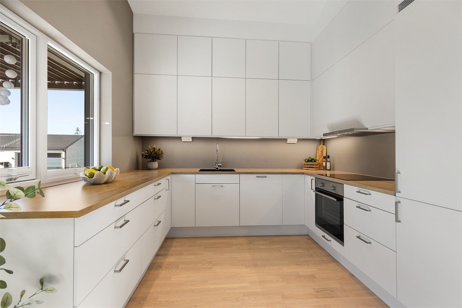 Godt med skap- og benkeplass, samt lys under overskapene, gjør kjøkkenet både praktisk og funksjonelt.