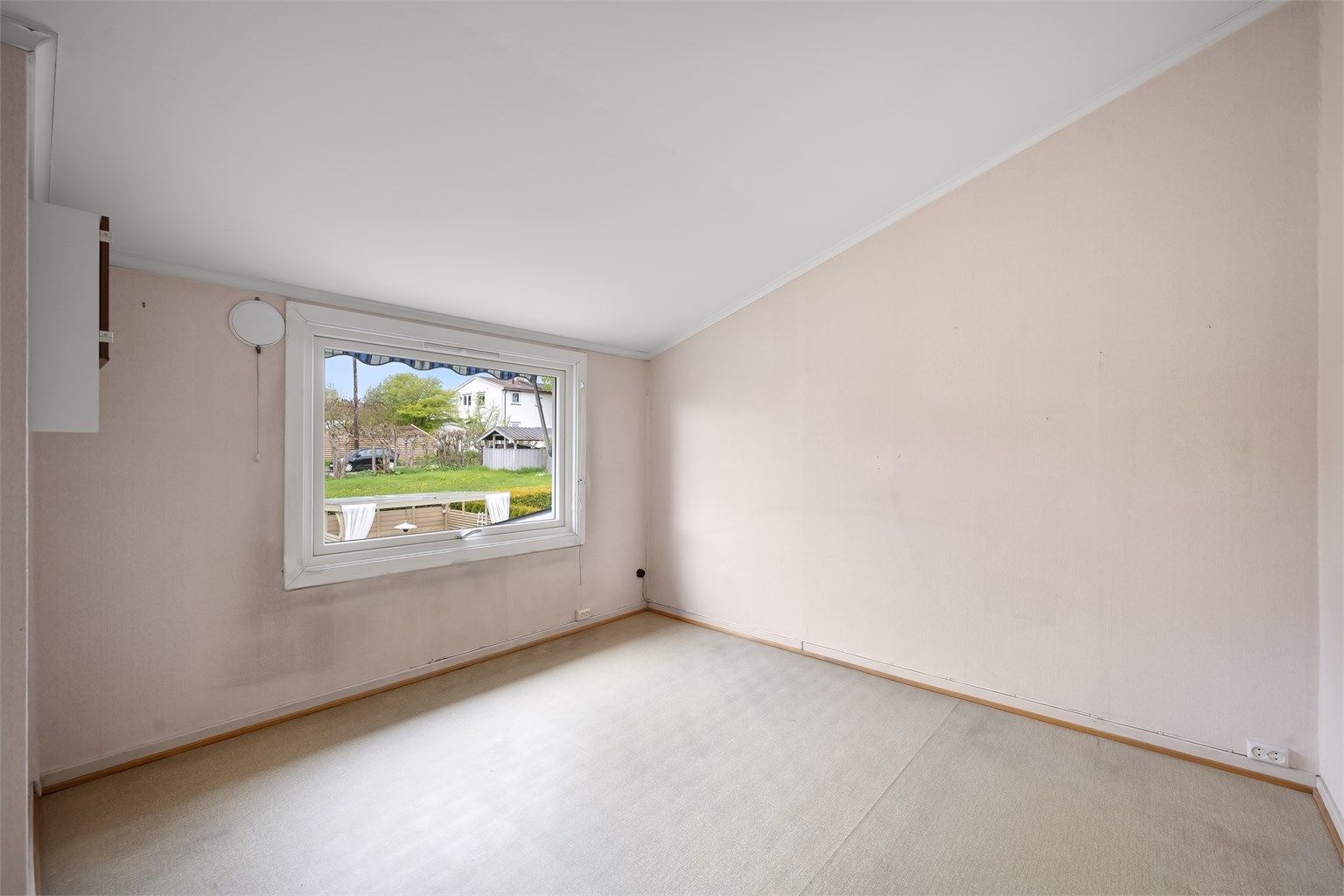 Det andre soverommet i etasjen vender mot boligens inngangsparti og hage.