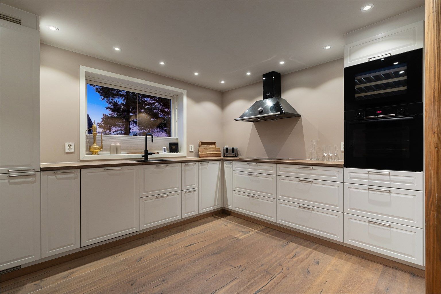 Lyst og pent kjøkken med integrerte hvitevarer 