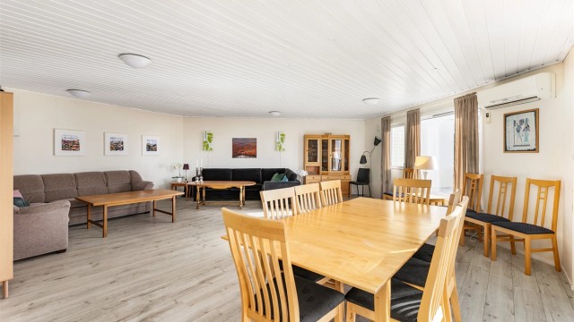 Stort selskapslokale møblert med både sofagrupper og spisegruppe.