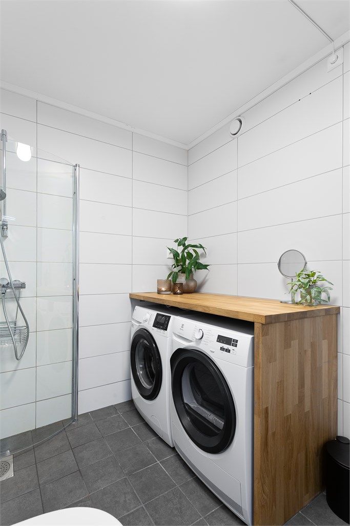 Opplegg for vaskemaskin og tørketrommel under benkeplate på badet.