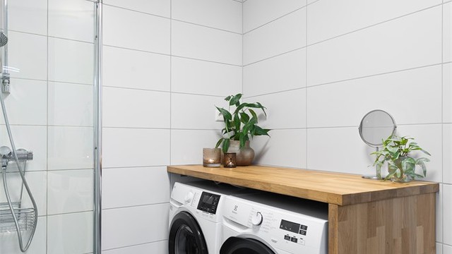 Opplegg for vaskemaskin og tørketrommel under benkeplate på badet.