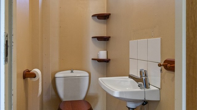 Praktisk toalettrom i første etasje, utstyrt med servant og toalett.
